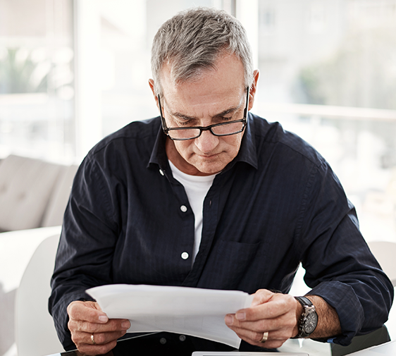 A man with glasses looking at documents.
